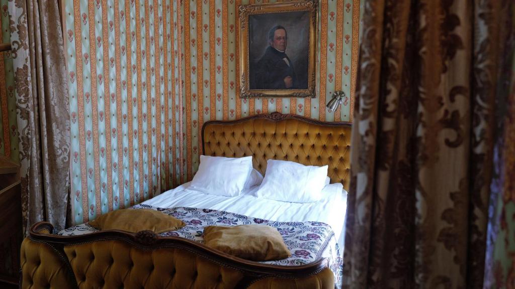 a bedroom with a bed with a portrait of a man at Börsen Apartment Suites in Visby