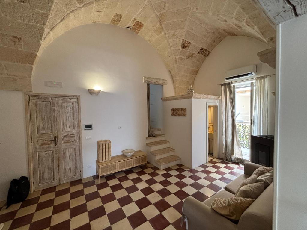 a living room with a couch and a checkered floor at DimoraStella in Pezze di Greco