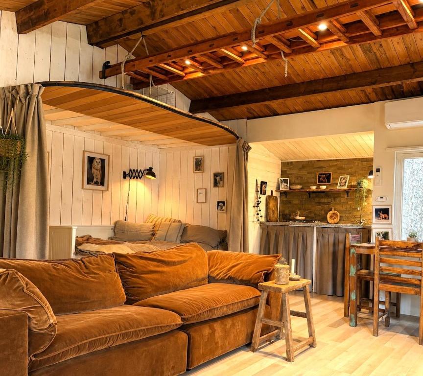 a living room with a brown couch and a kitchen at Little Bali in Geel