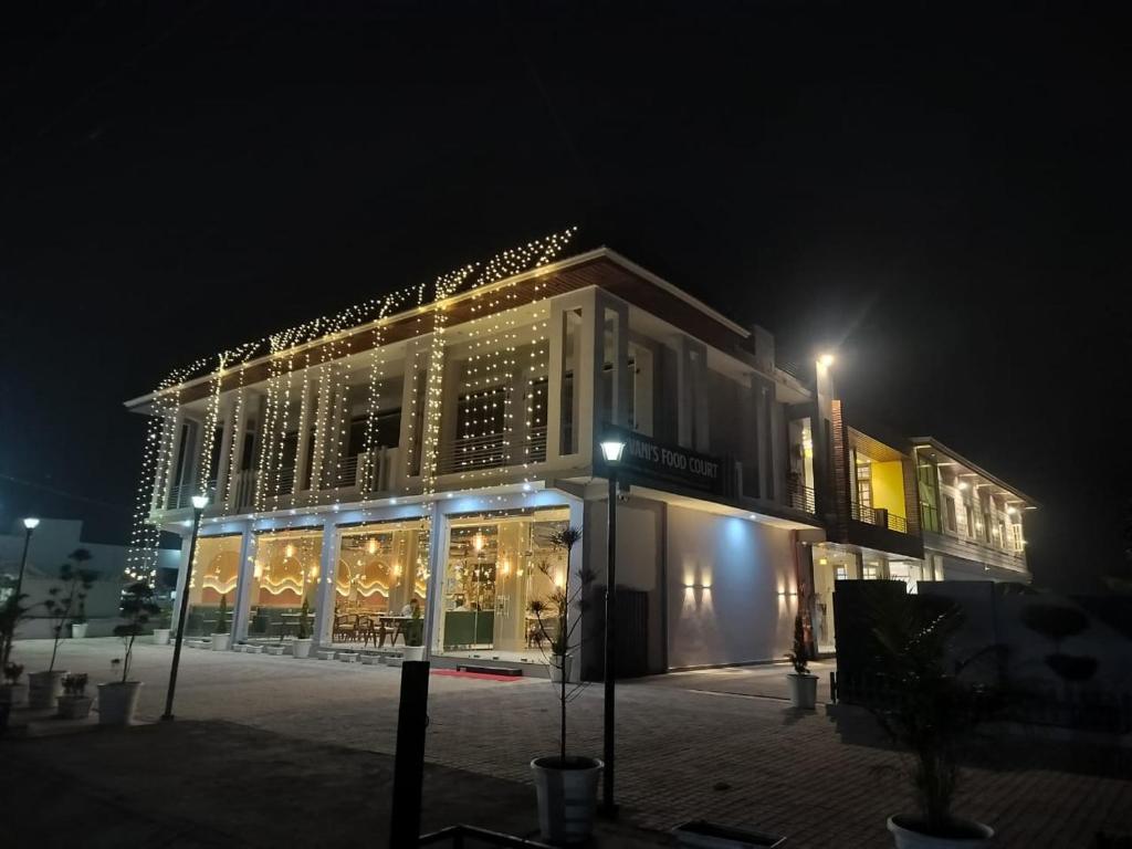 a large building with lights on it at night at Vani Hotel Golden Petals in Una