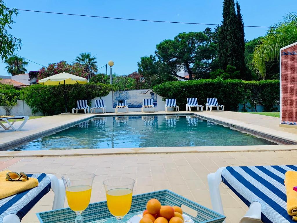 a table with two glasses of orange juice and fruit on it at Charming House in Carvoeiro + Pool in Carvoeiro