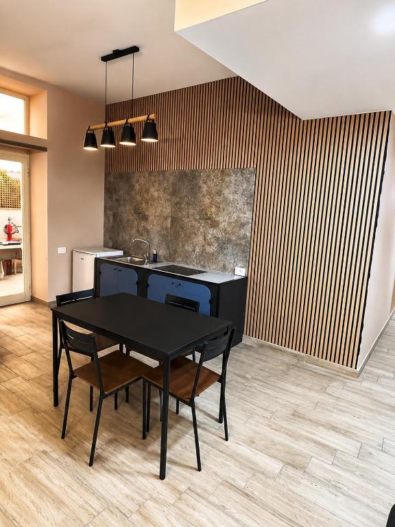 a kitchen with a black table and chairs in a room at Lo Studio della Riviera in Naples
