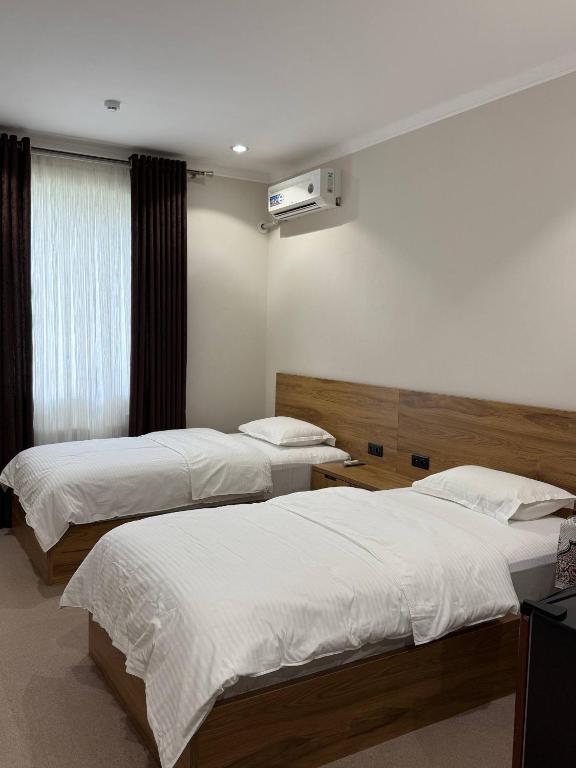 a hotel room with two beds and a television at Al-Amin in Termiz