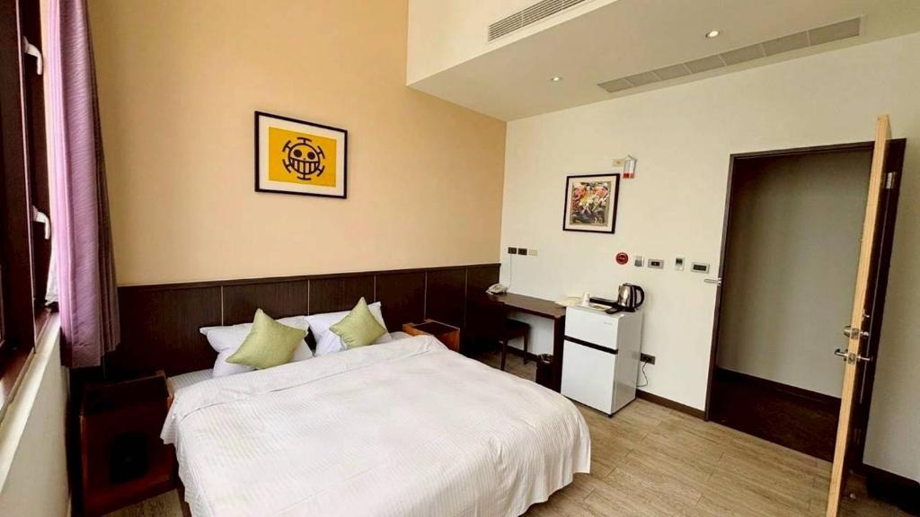 a bedroom with a white bed and a refrigerator at 儷景民宿 in Magong