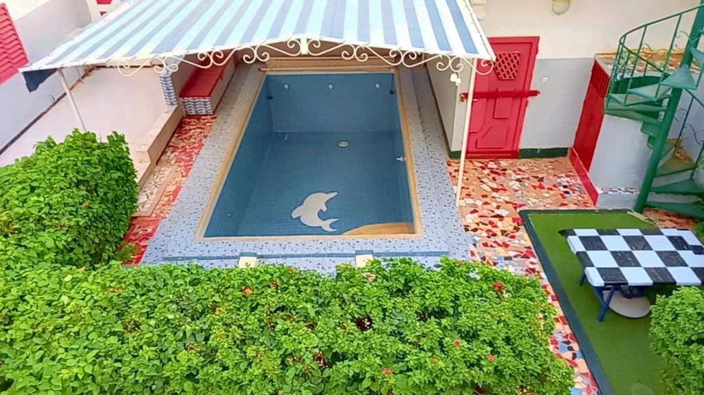 a toy house with a dog in the middle of a pool at Spacious Apartment with Pool in M'bour - 100 m² in Mbour