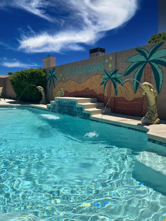 a swimming pool in front of a building with a mural at Mirage Pool House - Heart of LV, Swimming Pool, Games, heavenly relaxation in Las Vegas