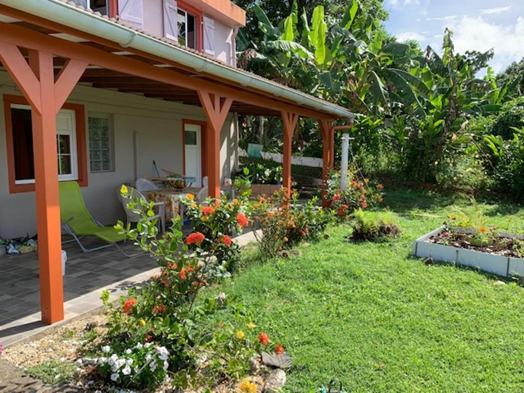 a house with a garden with flowers in the yard at Appartement charmant à Rivière-Salée, 45 m² avec terrasse privée in Rivière-Salée