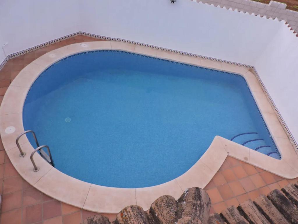 a large swimming pool in a building with blue water at Spacious Villa in Conil de Frontera with Private Pool in Roche