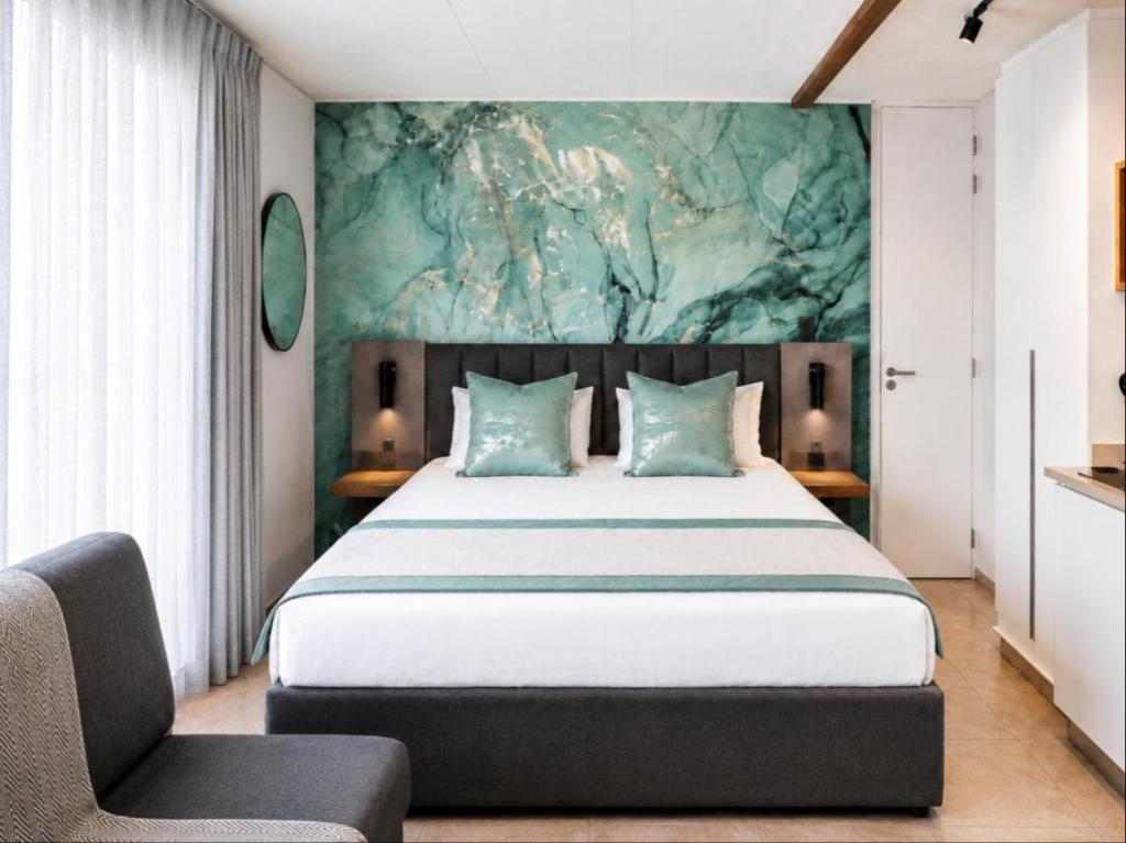 a bedroom with a large bed and a chair at Burleigh Ballito in Ballito