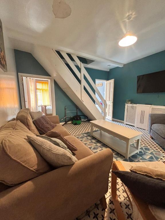 a living room with a couch and a staircase at Maple, 3 Double Beds, Contractors Welcome in Abertillery