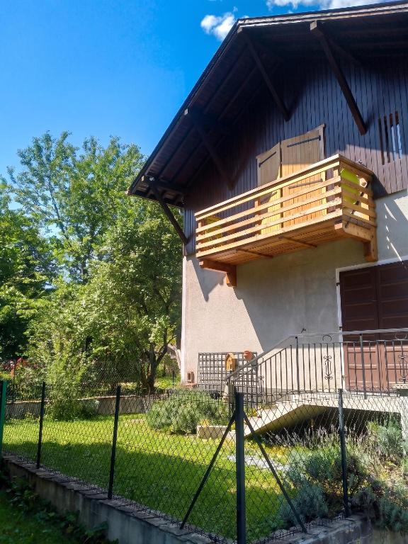 a house with a balcony on the side of it at Studio confortable à Taninges, 25 m² avec vue sur jardin in Taninges