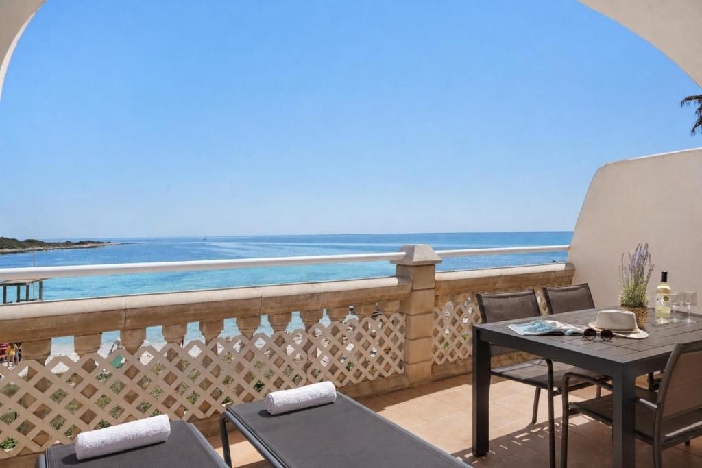 a balcony with a table and chairs and the ocean at Punta Prima Apartments by 3VILLAS in Punta Prima