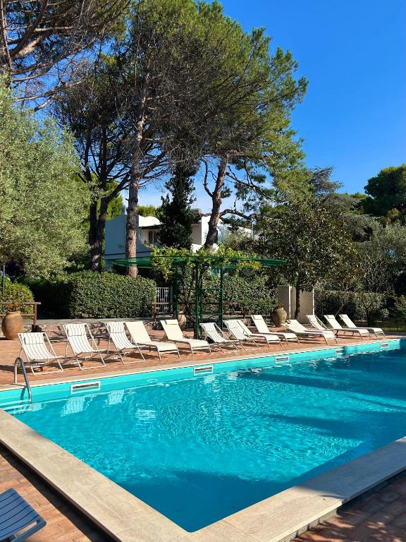 a swimming pool with chaise lounge chairs and trees at Villa Pineta - Holiday House in Anacapri