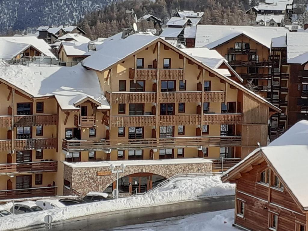 a large apartment building with snow covered roofs at Appartement cosy à Pelinche, Risoul - 30m² in Risoul