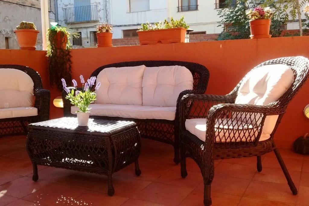 two wicker chairs and a couch on a patio at Charming Apartment in Castelserás - 60 sqm - Parking included in Castelserás