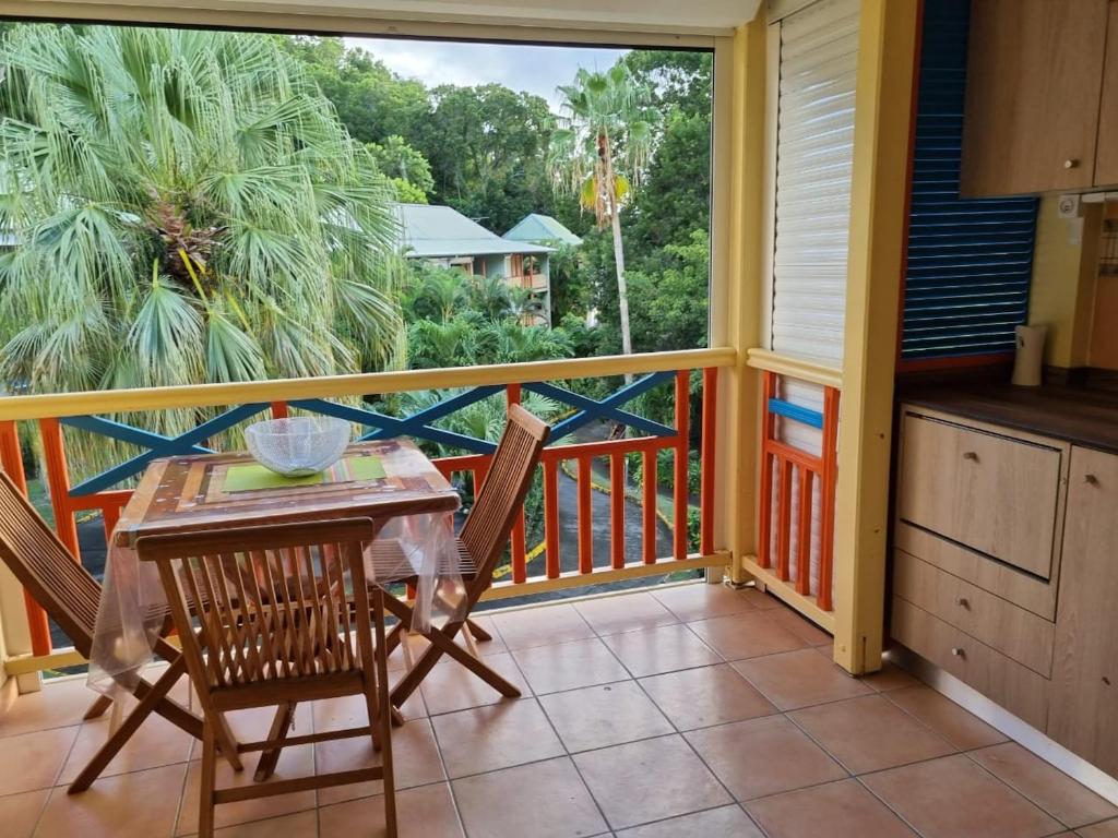 a porch with a table and chairs on a balcony at Studio charmant à Sainte-Anne de 25 m² avec terrasse et jardin. in Sainte-Anne