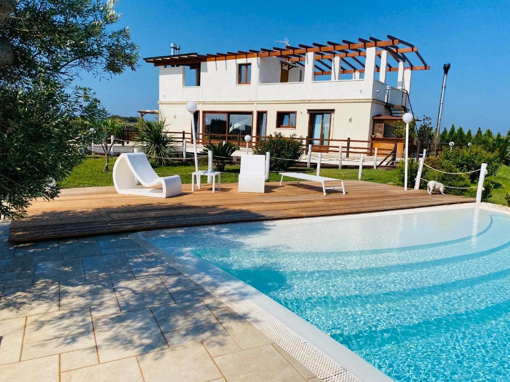 a villa with a swimming pool in front of a house at Charming Apartment in Nardò with Shared Pool in Nardò