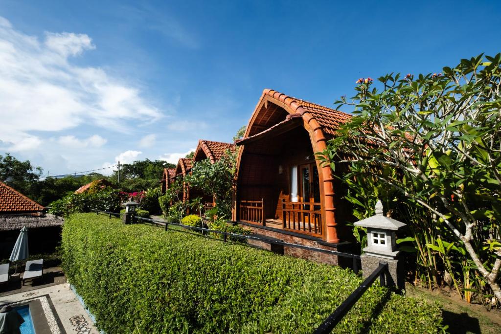 a house with a porch and a bird house at Druwa Bali in Uluwatu