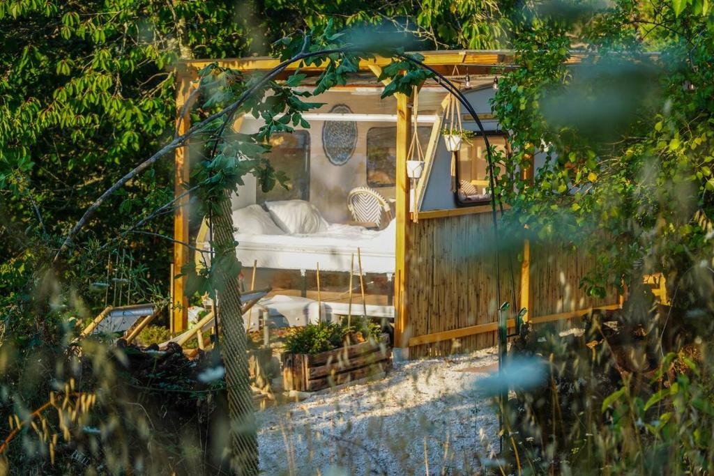 ein kleines Haus mit einem Bett in der Mitte in der Unterkunft Cherry Tree Caravan in Podentes