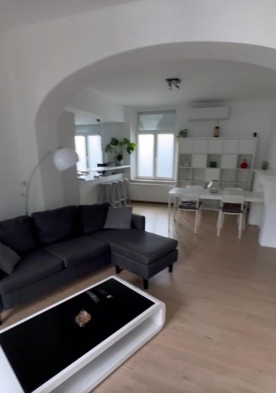 a living room with a black couch and a table at la casa de gege in Mellet