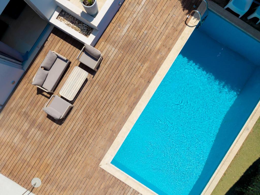 an overhead view of a swimming pool with two chairs at The peaceful escape with shared pool in Porto Rafti