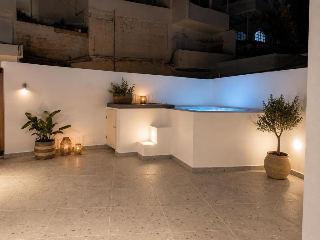 a room with two potted plants and a blue light at Pattys Desing Suites- Private Hot Tub with yard- Fira Center in Firostefani