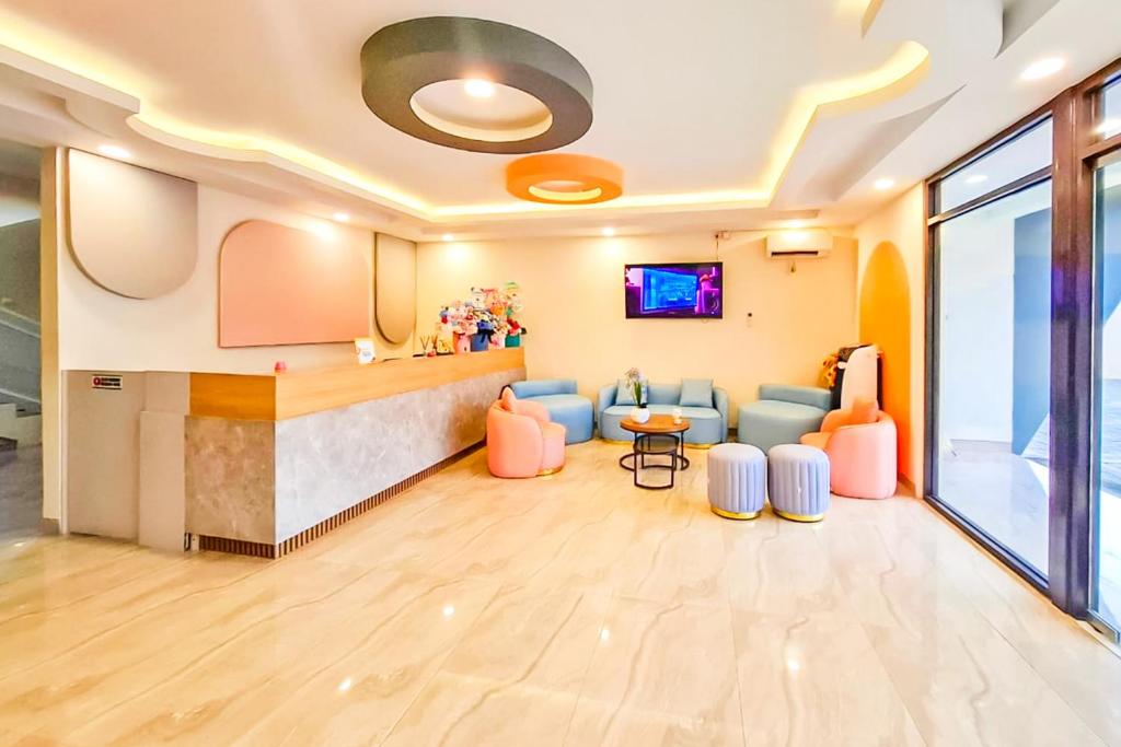a lobby with a waiting room with chairs and a table at SANS Hotel Joy Inn Brebes in Ketanggungan