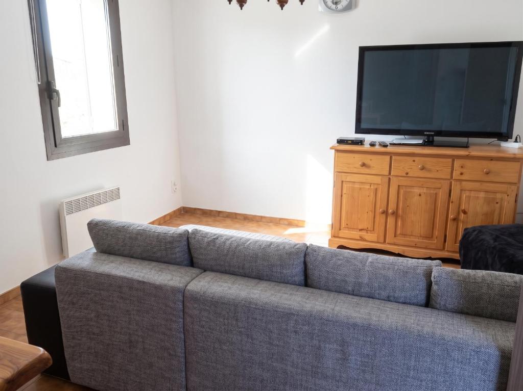 a living room with a couch and a flat screen tv at Appartement charmant avec vue sur lac et montagne – 75 m² in Fontrabiouse
