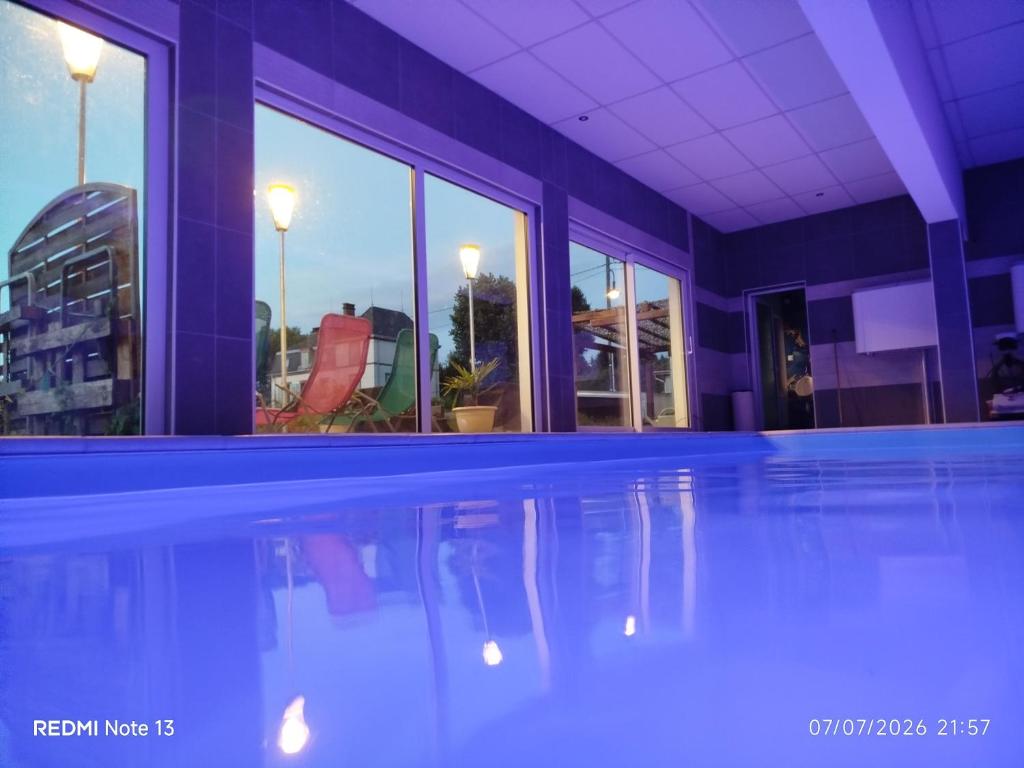 a swimming pool with a view of a building at Gîte "fils de laine" Piscine chauffée interieure et Sauna ouverts toute l'année in Celles-sur-Plaine