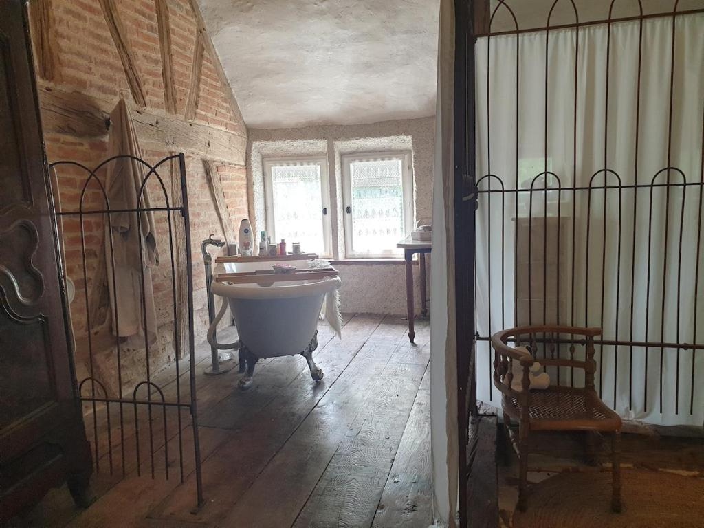 a bathroom with a tub and a sink in a room at Charming room in Sornay