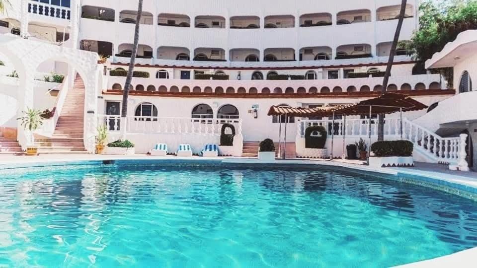 a large swimming pool in front of a building at CH Paradise Condesa in Acapulco