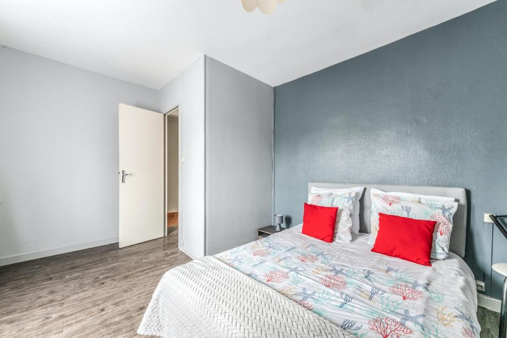 a bedroom with a large bed with two red pillows at Maison conviviale à Bourbon-Lancy avec équipements modernes in Bourbon-Lancy