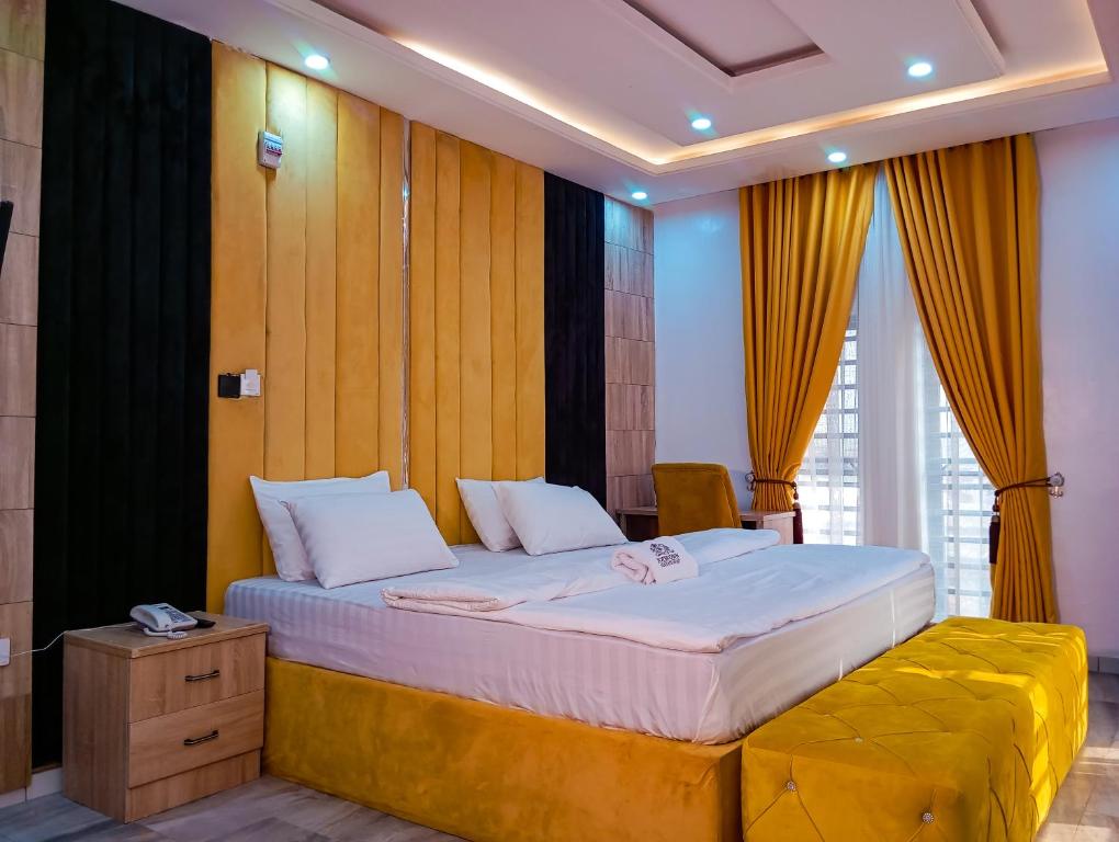 a bedroom with a large bed with a yellow couch at Joebrown Palace Hotel & Suite in Akitan