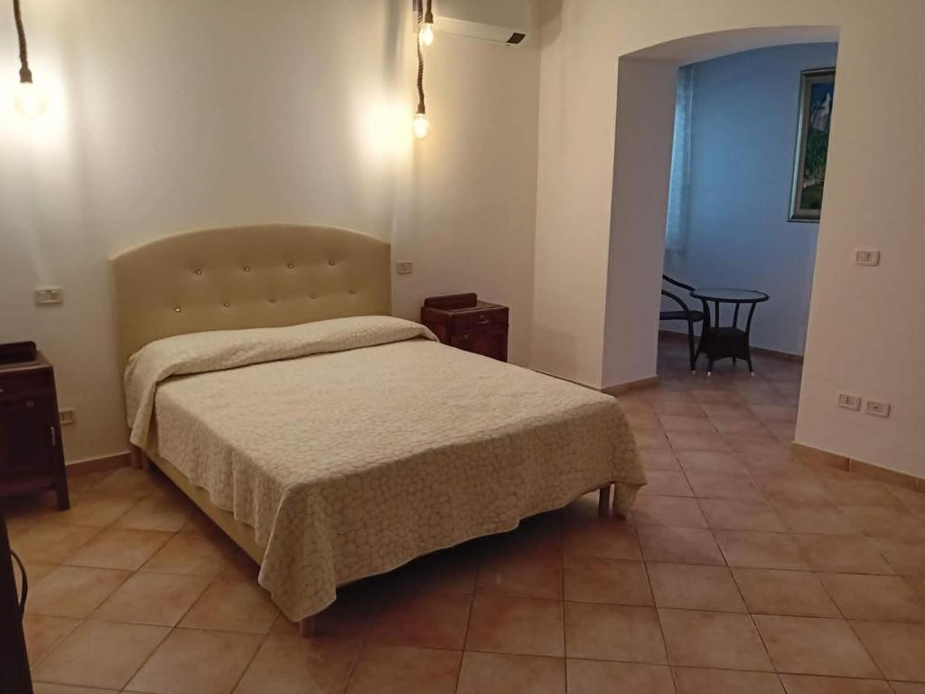 a bedroom with a bed and a table at beucarnea apartment salerno in Eboli