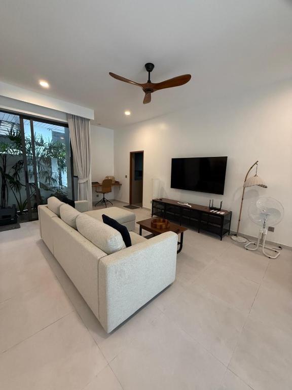 a living room with a couch and a flat screen tv at Villa Manu in Ko Phangan