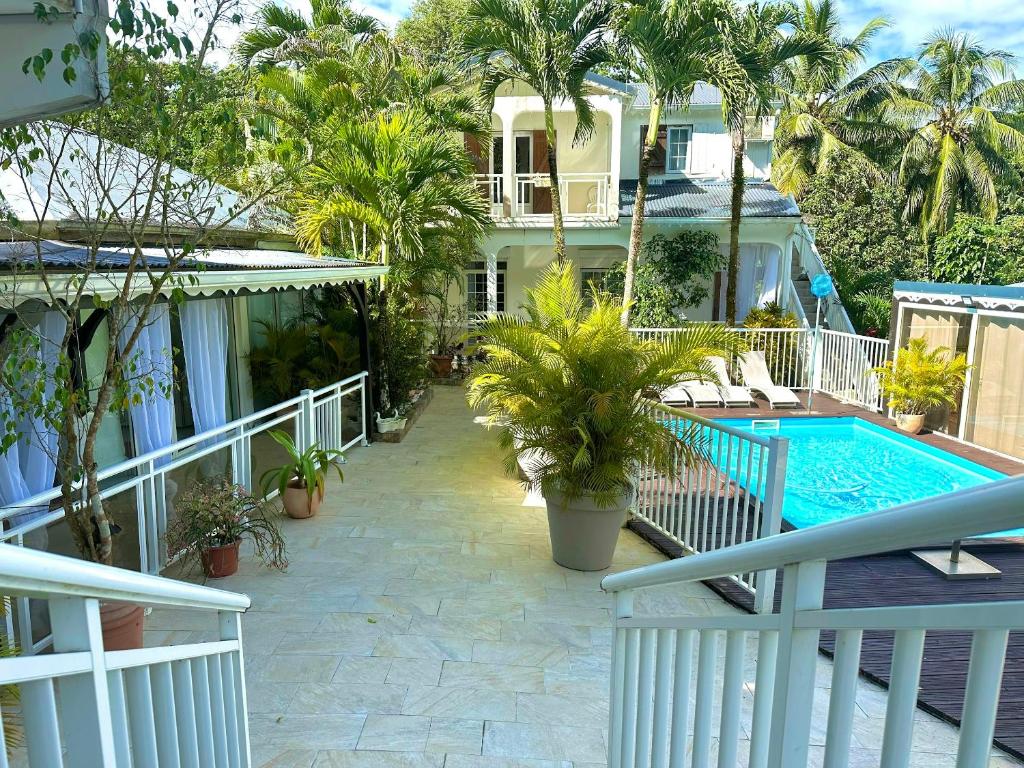 a balcony of a house with a swimming pool at Appartement charmant à Sainte-Rose, 60m² + piscine in Sainte-Rose