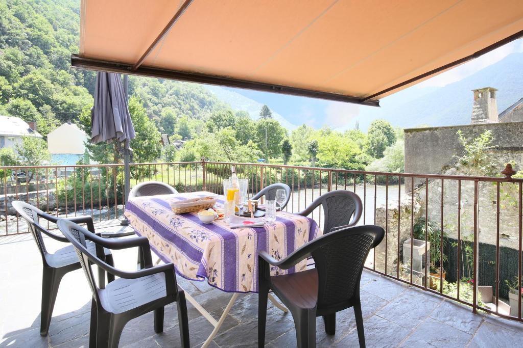 a table and chairs on a balcony with a view at Le chant de la garonne in Saint-Béat