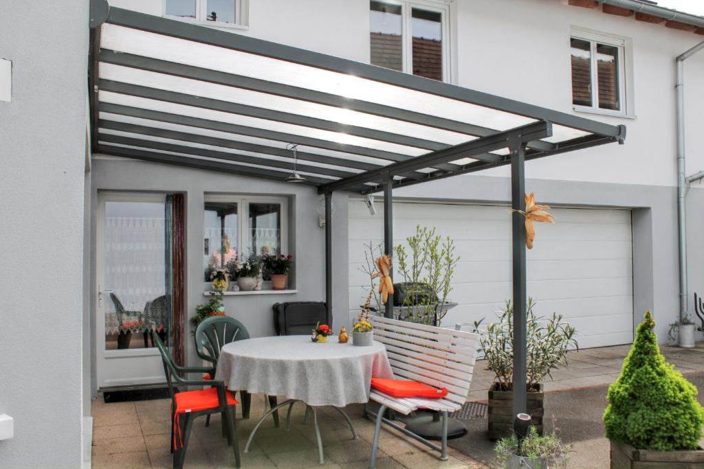 a patio with a table and chairs under a pergola at Studio charmant à Valff avec jardin privé - 20 m² in Valff