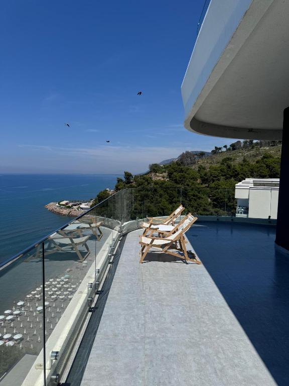 a balcony with chairs and a view of the ocean at Angelo Apartments Ilyonis Residence in Shëngjin