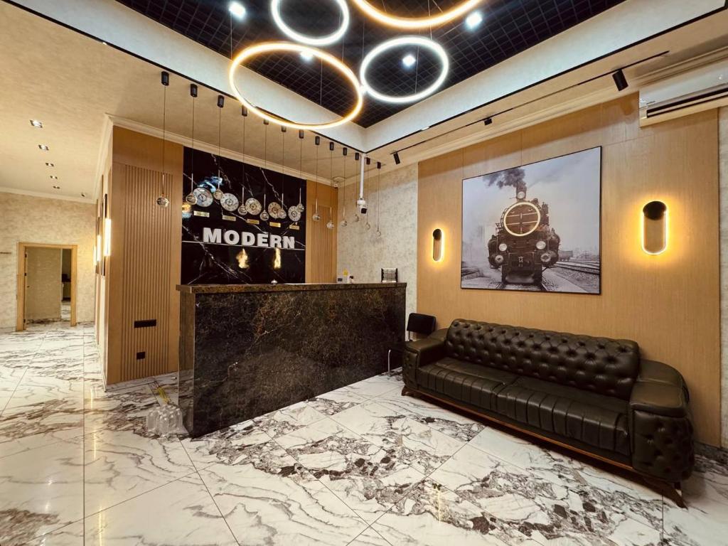 a lobby with a couch and a poster of a train at Modern Hotel in Tashkent