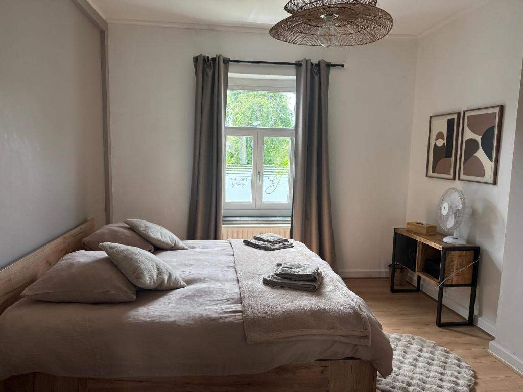 a bedroom with a large bed and a window at Loft by GIORGI - Centre de Bastogne in Bastogne