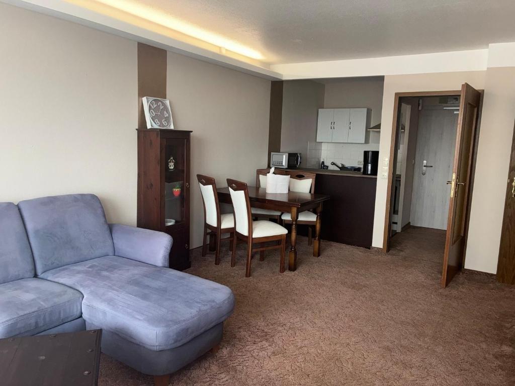 a living room with a couch and a table and a kitchen at Apartment 231 in Hohegeiß