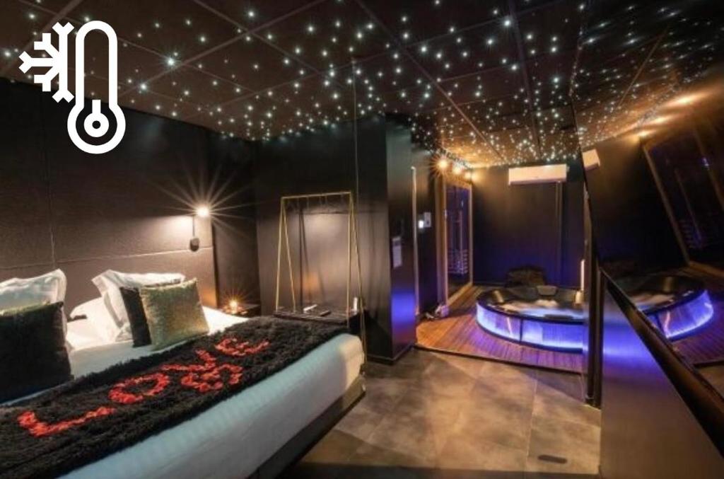 a bedroom with a bed and a tub with lights at Suite Chic - Antre-parenthèse in Gravelines