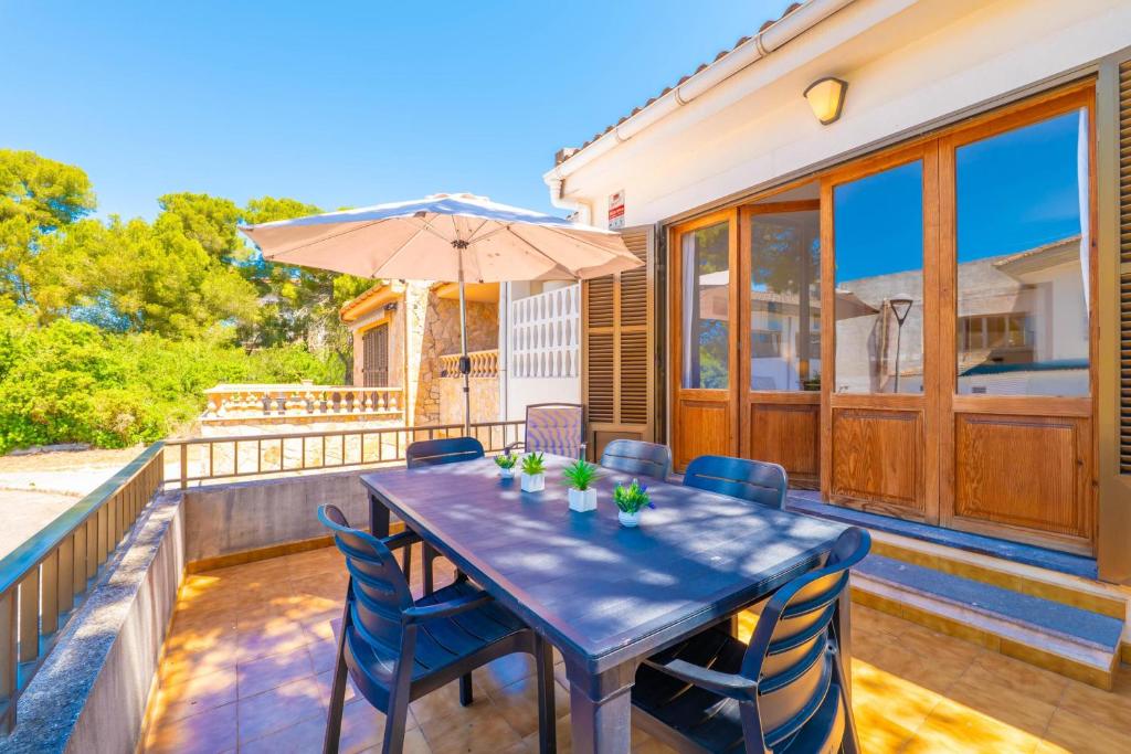a patio with a table and chairs and an umbrella at PDM CA'N NOFRE in Playa de Muro