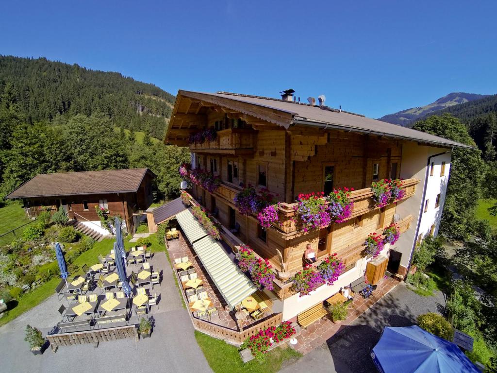 an aerial view of a building with flowers and tables at Gasthaus Steinberg in Westendorf