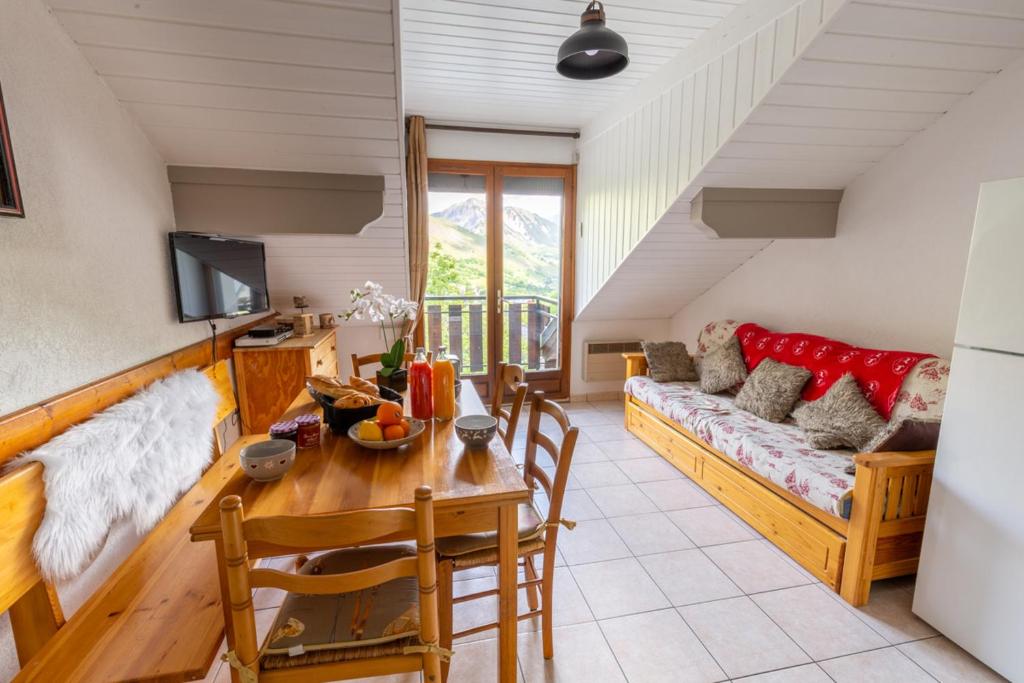 a living room with a table and a couch at Appartement Douillet Saint-Sorlin-d'Arves 49 m² Vue montagne in Saint-Sorlin-dʼArves