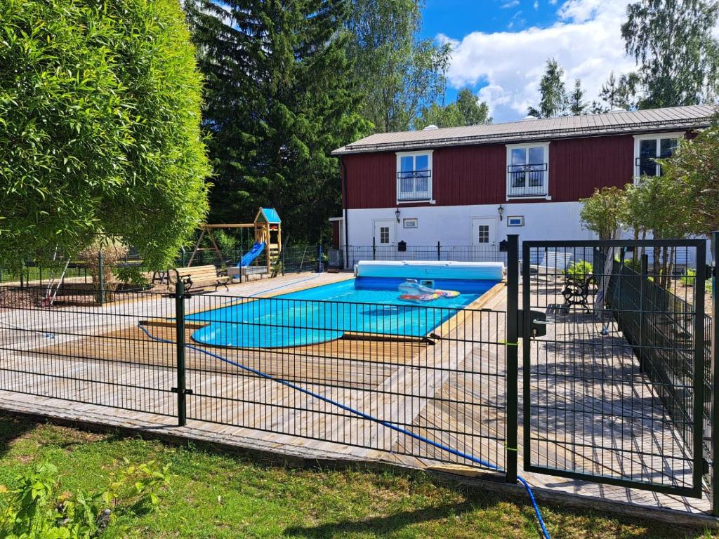 a fence with a pool in front of a house at Marieborg Apartments in Ekshärad