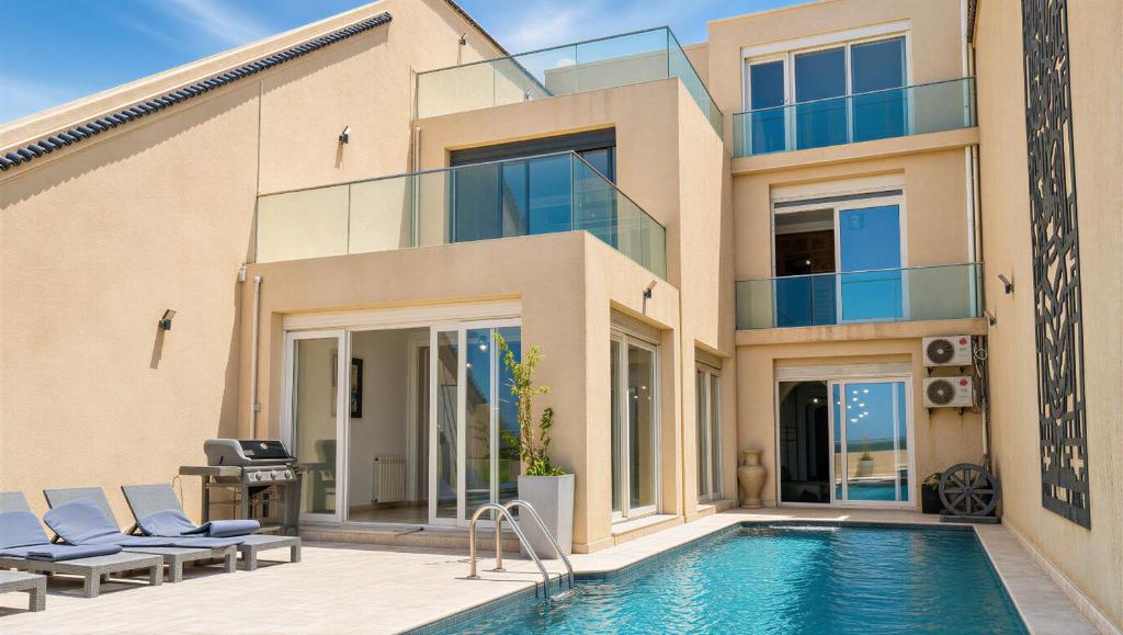 a house with a swimming pool next to a building at Sea-View Villa with Infinity Pool Algiers in Tipaza