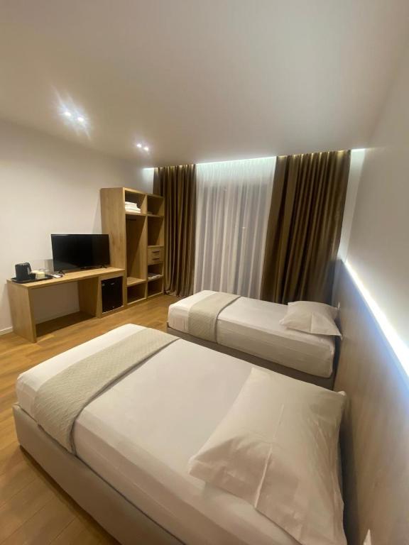 a hotel room with two beds and a television at Villa SkyWay in Krujë