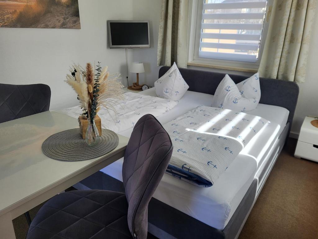 a bedroom with a bed and a desk with a table at kleines feines Kühlungsborn, Studio mit Terrasse, Parkplatz & WLAN, 300m vom Strand entfernt in Kühlungsborn